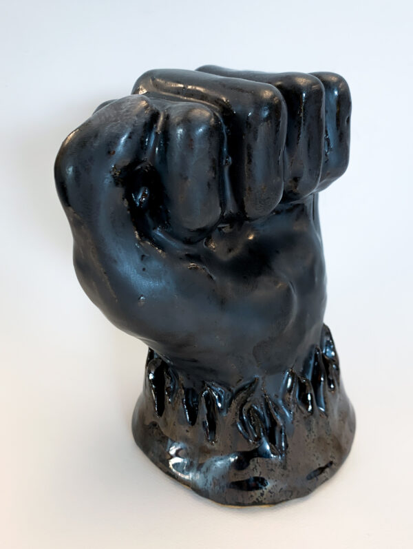 Rachel Parry, grade 11, "Flaming Fist of Anger," ceramics, 7x4x5 in. The process of creating a ceramic sculpture can be tricky. Not only does the artist have to have strong technical knowledge to make a sculpture look appealing and physically balanced, but much is left up to chance during the firing and glazing process. During this process, pieces can crack or explode and glaze can run, flake off, or come out differently than expected. In this sculpture, everything went according to plan. This piece is a physical interpretation of the way anger feels. In this sculpture, Rachel represents anger as a fist surrounded by flames of rage.